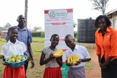 1.-As-our-core-value-we-value-health.-Learners-and-a-teacher-of-Mudakori-school-proudly-show-off-the-fruits-they-received-from-Organic-Impact